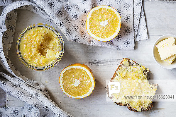 Orangenscheibe und hausgemachte Marmelade mit Brot und Butter auf dem Tisch