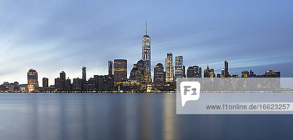 USA  New York  New York City  Lower Manhattan with One World Trade Center illuminated at dawn seen across river
