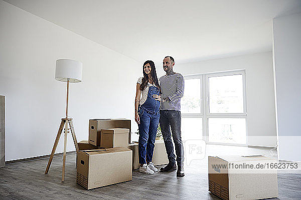 Couple standing on floor with cardboard boxes