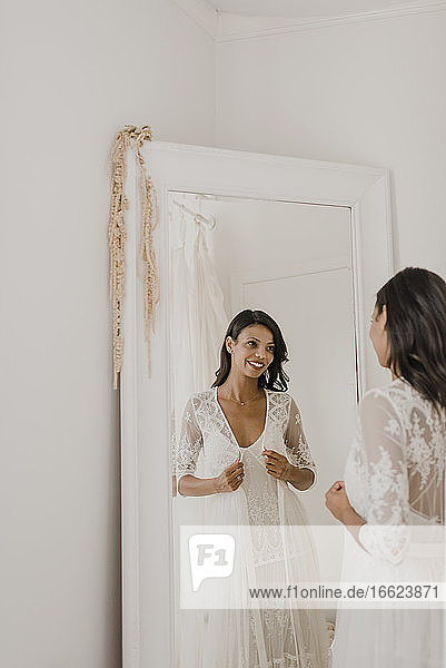Reflexion der jungen Braut im Spiegel zu Hause