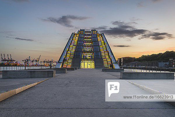 Deutschland  Hamburg  Beleuchtetes modernes Bürogebäude in der Nähe des Docks bei Sonnenuntergang