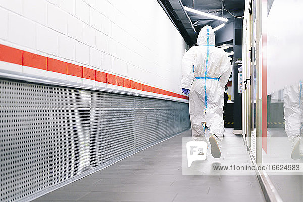 Healthcare man walking while wearing protective suit in hospital