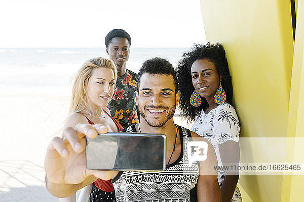 Freunde machen ein Selfie in der Rettungsschwimmer-Hütte am Strand