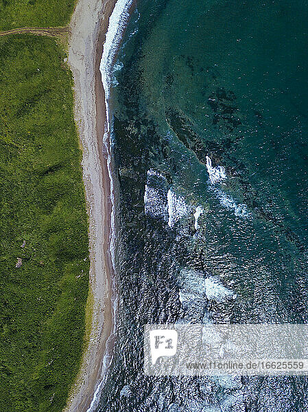 Aerial view of dirt road stretching along coastline of Krabbe Peninsula