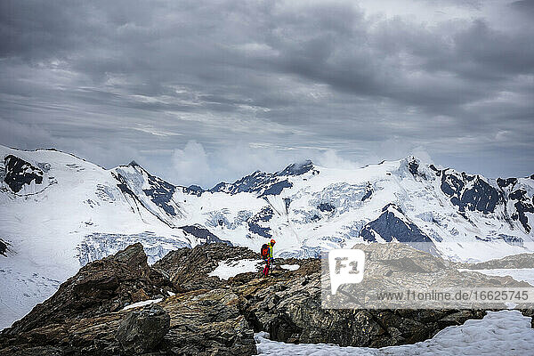 Mature man standing on rock against cloudy sky  Stelvio National Park  Italy