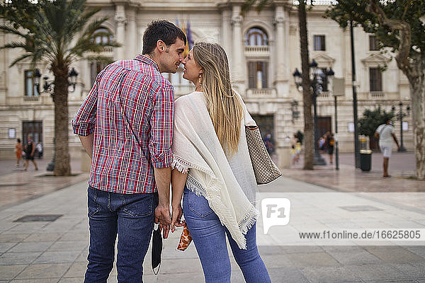 Paar kuschelt sich an die Nase  während es in der Stadt steht