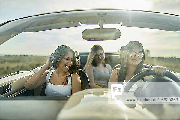 Freunde haben Spaß  während sie im Cabrio unterwegs sind