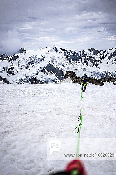 Mature man with rope walking on snow covered landscape against sky  Stelvio National Park  Italy