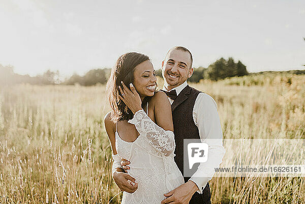 Lächelndes Paar verbringt seine Freizeit auf einem Feld an einem sonnigen Tag