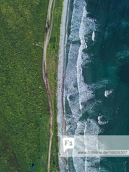 Aerial view of dirt road stretching along coastline of Krabbe Peninsula