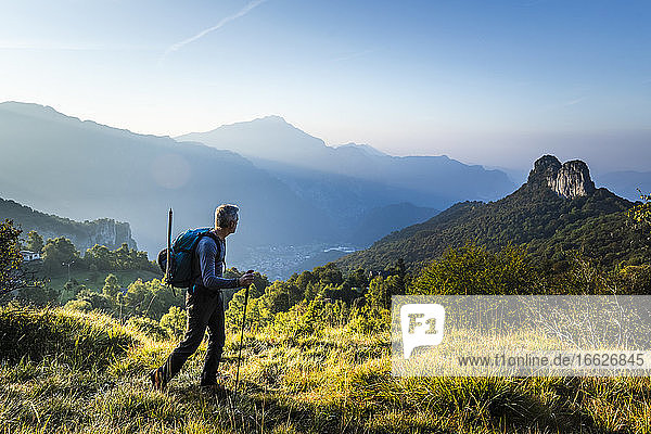 Männlicher Wanderer mit Stock auf einem Berg gegen den Himmel bei Sonnenaufgang  Orobie  Lecco  Italien