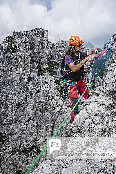 Älterer Mann mit Seilen auf einem Berg stehend  Europäische Alpen  Lecco  Italien