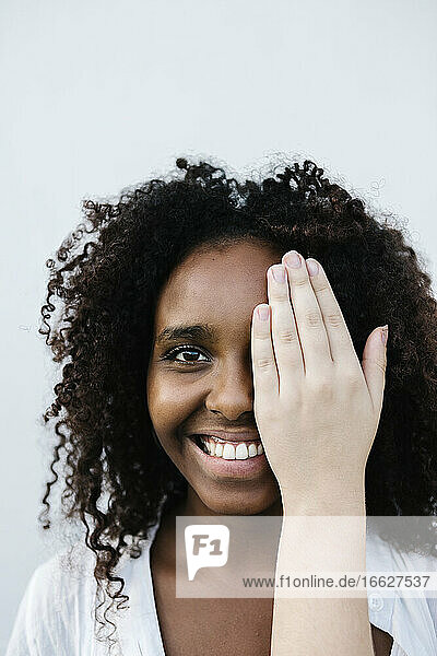 Hand covering face of smiling woman