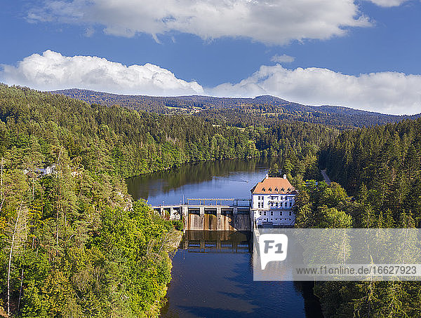 Drone view of hydroelectric power station on Hollensteinsee lake and surrounding forest in summer