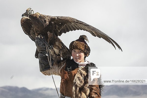 Young eagle hunter with her female eagle Olgii Mongolia Asia