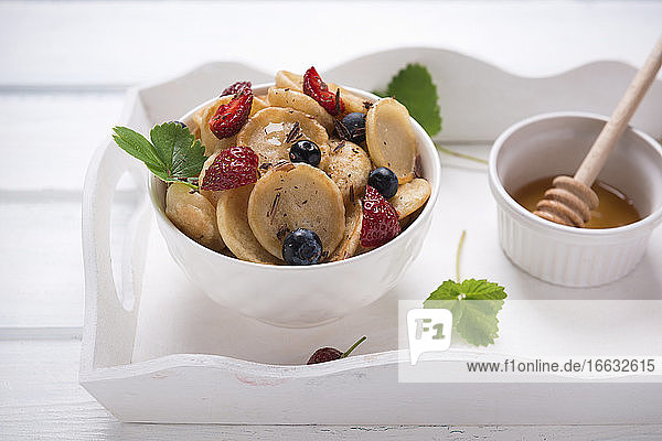 Vegan mini pancake bowl with berries  sugar syrup and chocolate