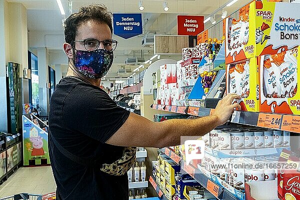 Berlin  Germany. Mature gay male shopping for groceries inside a local supermarket wearing a 'protective' facemask due to Corona Outbreak and Covid-19 Crisis. In Germany facemasks are mandatory in every enclosed  public space. Meanwhile prices of daily groceries are rocketing due to inflation.