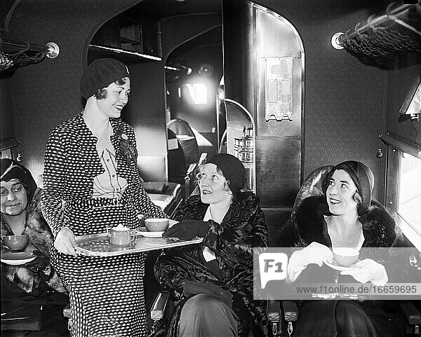 Vereinigte Staaten  10. Januar 1931.
Eine Stewardess der Eastern Air Transport serviert Tee für die Passagiere  denen zu ihrer Unterhaltung auch Zigaretten und Bridge-Spiele zur Verfügung stehen.