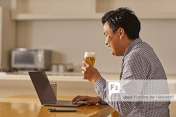 Japaner  der zu Hause trinkt  trinkt aus der Ferne