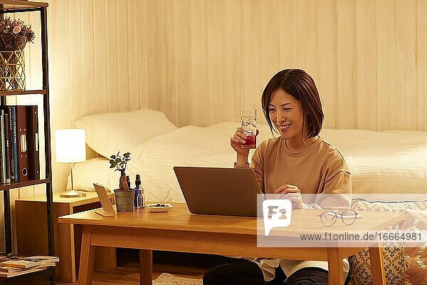 Japanese woman drinking at home remote drinking