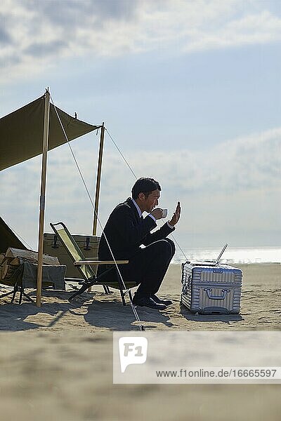 Japanese businessman working at the beach