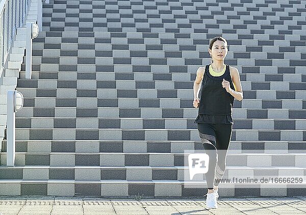 Junge japanische Frau beim Laufen in der Innenstadt von Tokio  Japan
