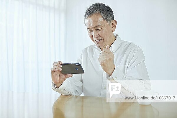 Japanischer Mann mittleren Alters  der im Zimmer lächelt