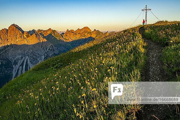 Kleiner Bergweg mit Bergsteiger und Gipfel der Üntschenspitze bei Sonnenaufgang  Schoppernau  Bregenzerwald  Vorarlberg  Österreich  Europa