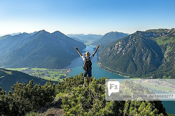 Hiker stretches arms in the air  view from Bärenkopf to Achensee  left Seekarspitze and Seebergspitze  right Rofangebirge  Karwendel  Achensee  Tyrol  Austria  Europe
