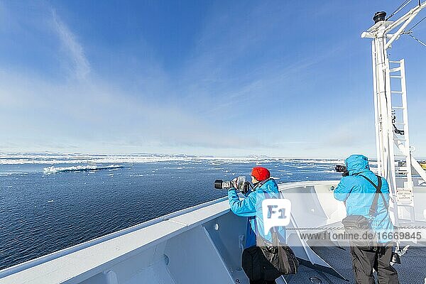 Passsagiere an Deck eines Kreuzfahrtschiffs  Eisberge  Meer  Ostküste Grönland  Dänemark  Europa