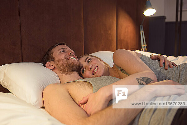 Glückliches Paar auf dem Bett liegend