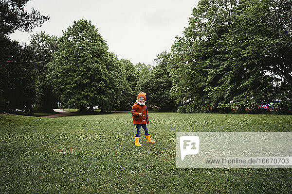 Young male child walking in the park on a cloudy day
