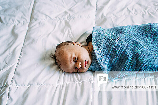 Überkopf des neugeborenen Babys  das auf einer weißen Decke schläft