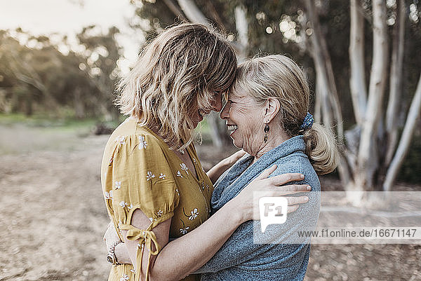 Lifestyle portrait of adult mother and senior mother smiling