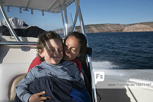 A mom and her son cuddling on a sailing boat at Espíritu Santo Island.