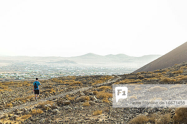 Man hiking through mountainous and desert landscape of Fuerteventura