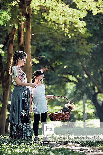 Mutter und Tochter pflücken Blumen im Park