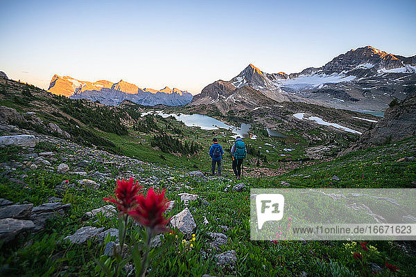 Ehepaar wandert gemeinsam bei Sonnenuntergang in den Rocky Mountains