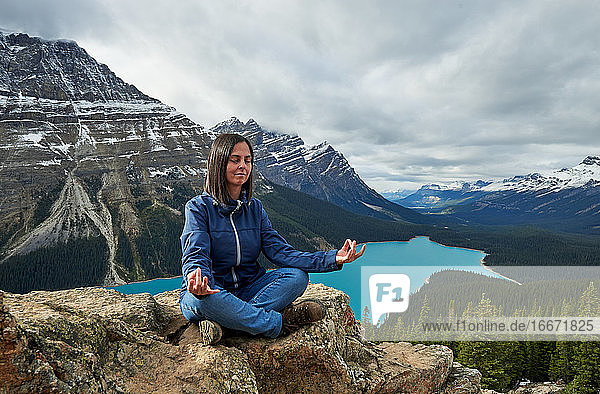 Relaxed woman doing Yoga in Peyto Lake  Banff National Park