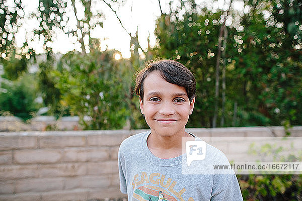 Porträt eines 10-jährigen Jungen im Freien bei Sonnenuntergang