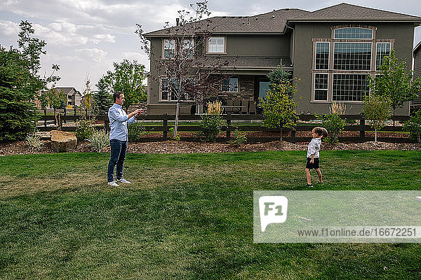 Vater und Sohn spielen Fangen im Hinterhof