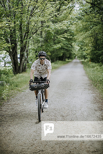 Männlicher Radfahrer fährt auf einem Schotterabschnitt des East Coast Greenway  Maine