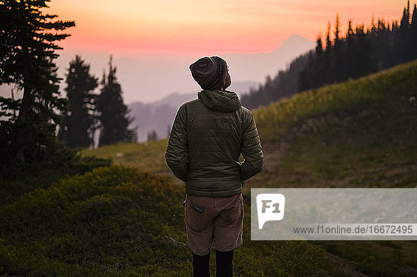 Male hiker watching sunset in the cascade mountains