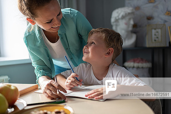 Glückliche Mutter und Sohn zeichnen zusammen