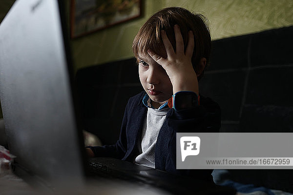 konzentriertes Kind  das am Computer sitzt