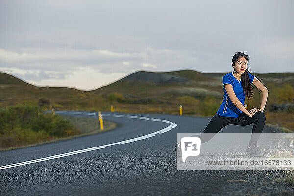 beautiful woman stretching during work out in rural area in Iceland