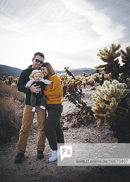 A family is standing near a cactus in the desert  California