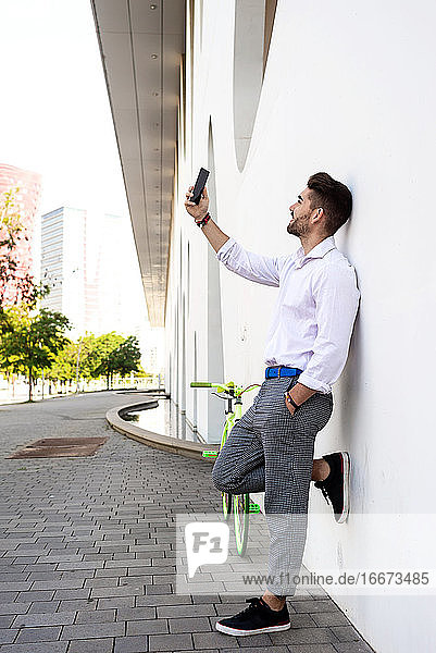 Porträt von stilvollen gut aussehend jungen jungen Mann  der selfies mit Telefon