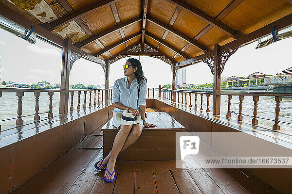 Schöne Frau entspannt sich auf einer Flussfahrt auf dem Chao Phraya