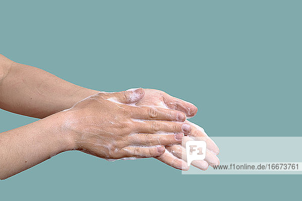 Frau wäscht Hände auf einem blauen Hintergrund. Hygiene-Konzept